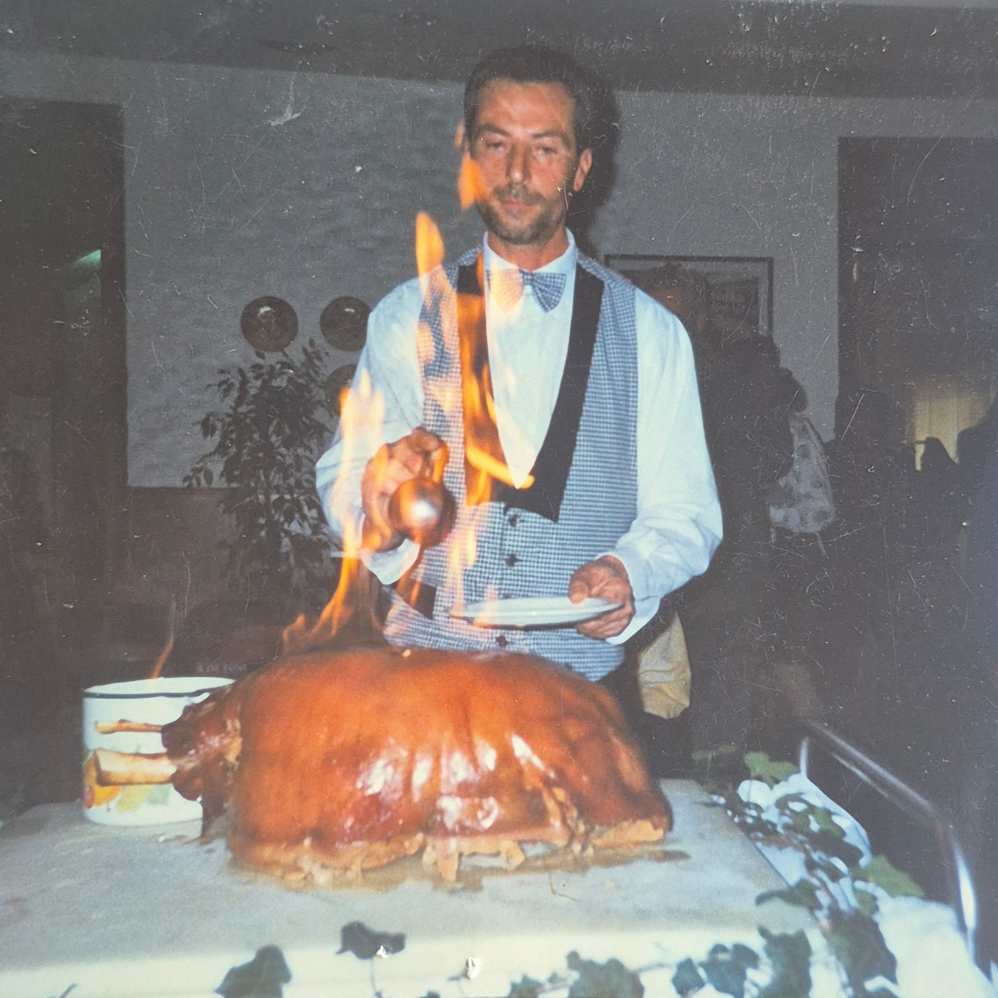 Un cameriere fiamma una porchetta durante un matrimonio al ristorante